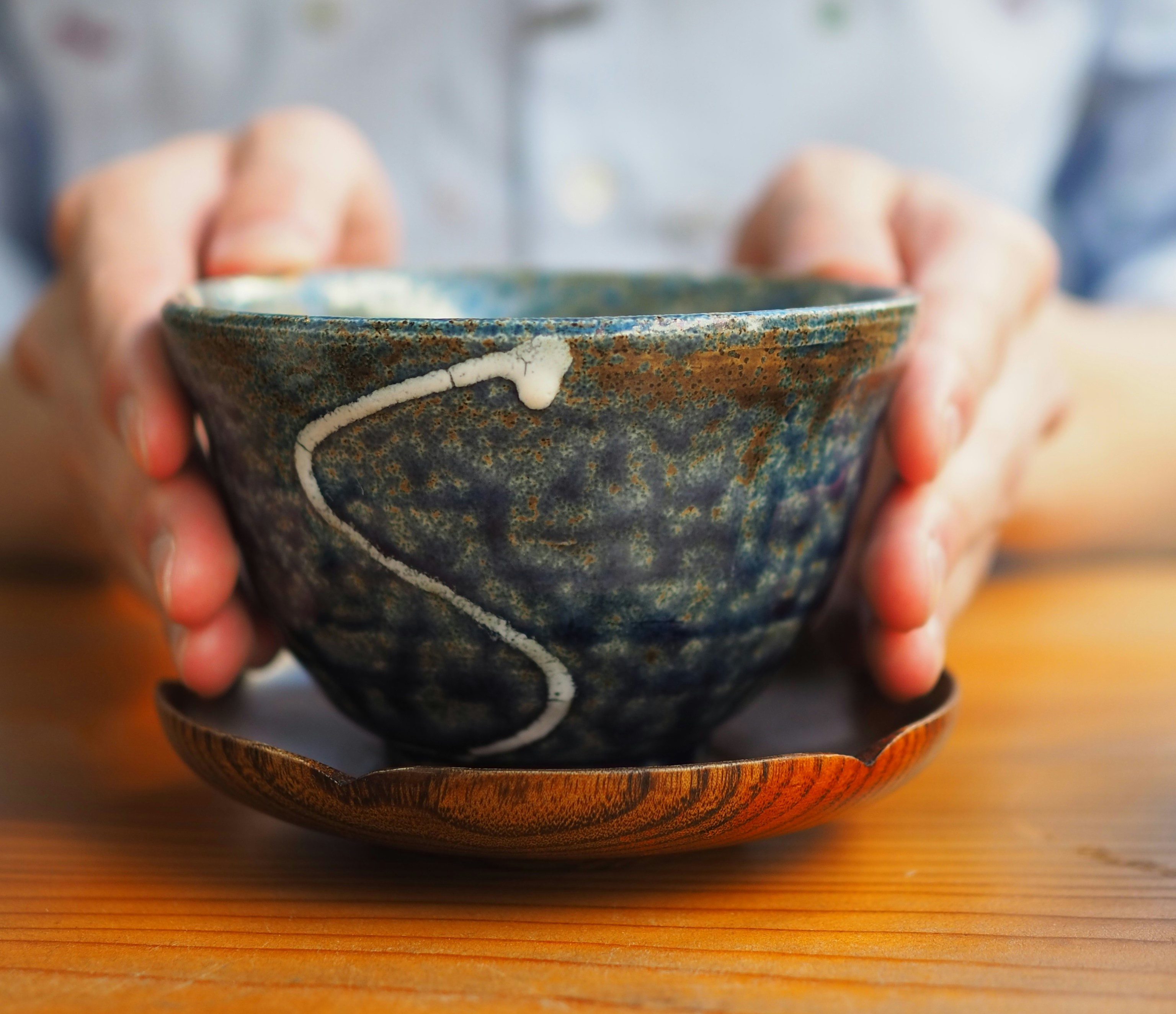 a hand holding a tea cup